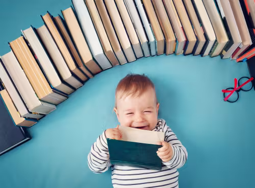 bébé souriant tenant un livre dans les mains