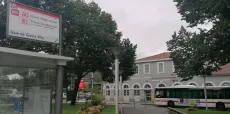 L'image montre la gare de Givors avec au premier plan un arrêt de bus. Devant la gare est stationné un Bus TCL.